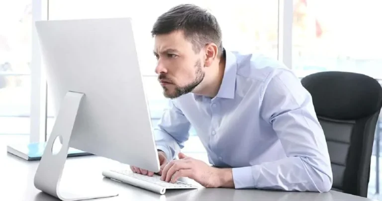 Desk worker with neck pain from looking at computer.